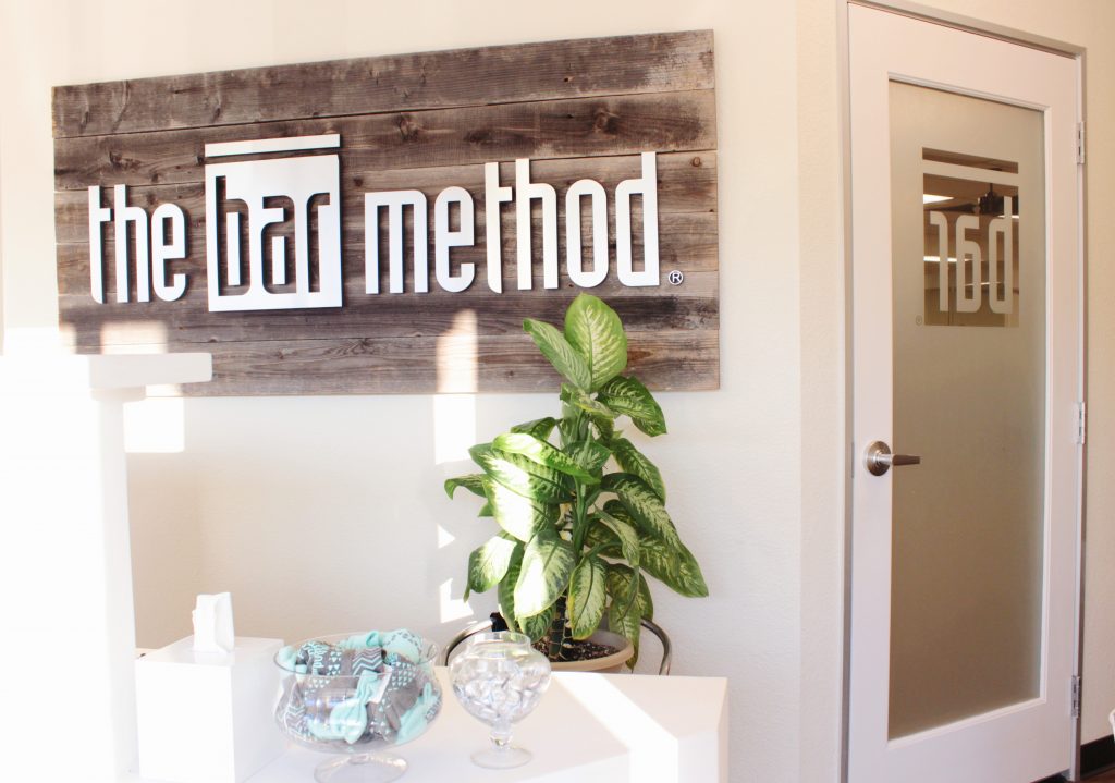 The Bar Method Logo Behind the Front Desk at the Bar Method Campbell