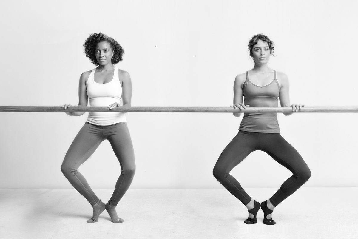 Two women are holding onto the barre while practicing diamond thigh.