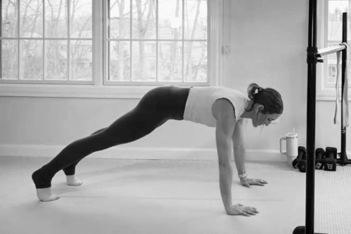Woman in an at-home Bar Method studio demonstrating a push-up.