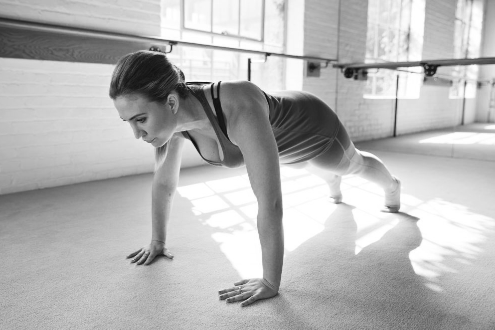 Woman in a barre studio performing a push-up. 