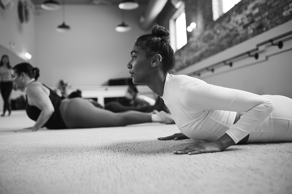 Women using a barre ball to build lean muscle in a Bar Method class.