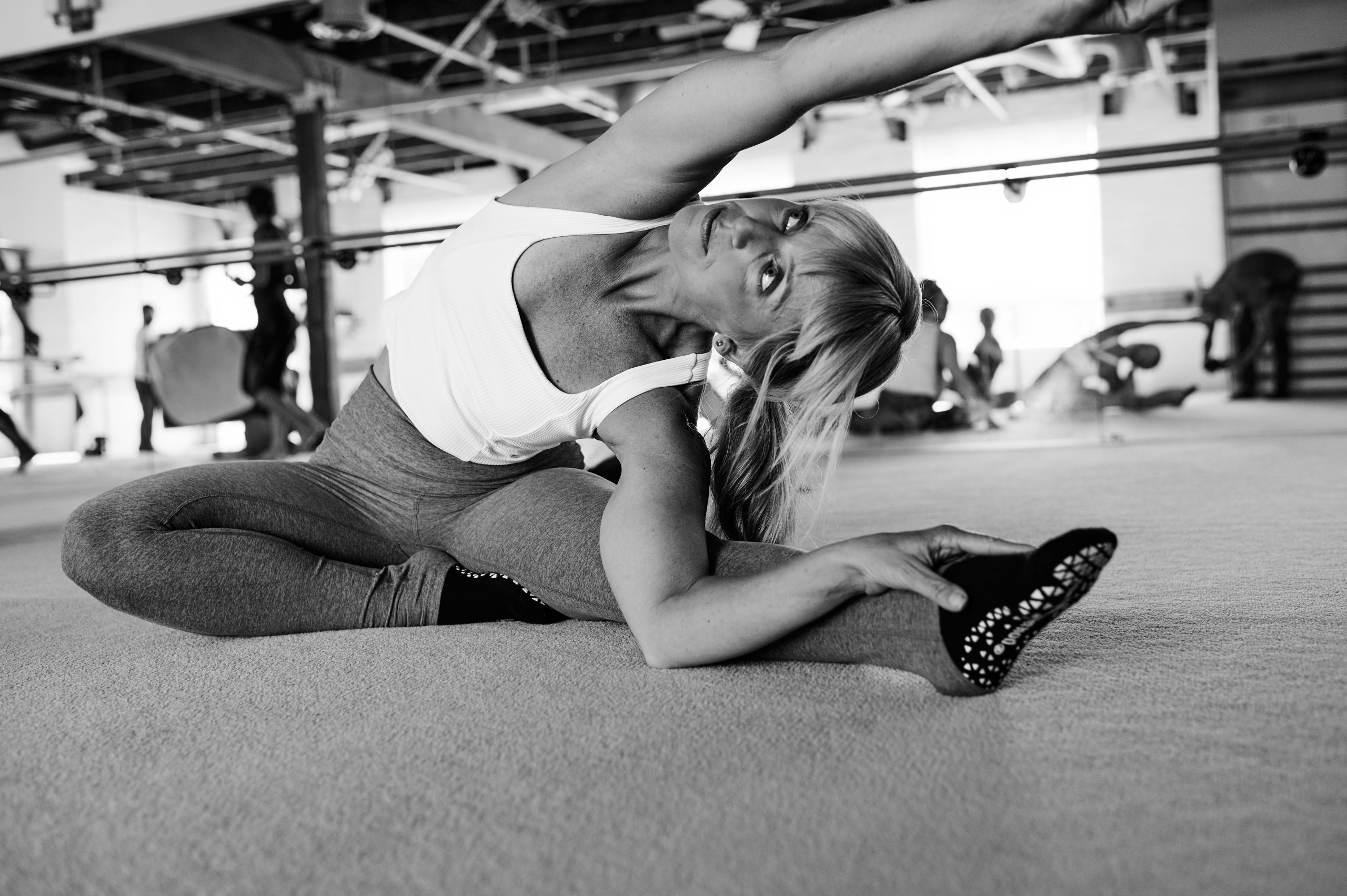Black and white image of woman's back on a bar method studio