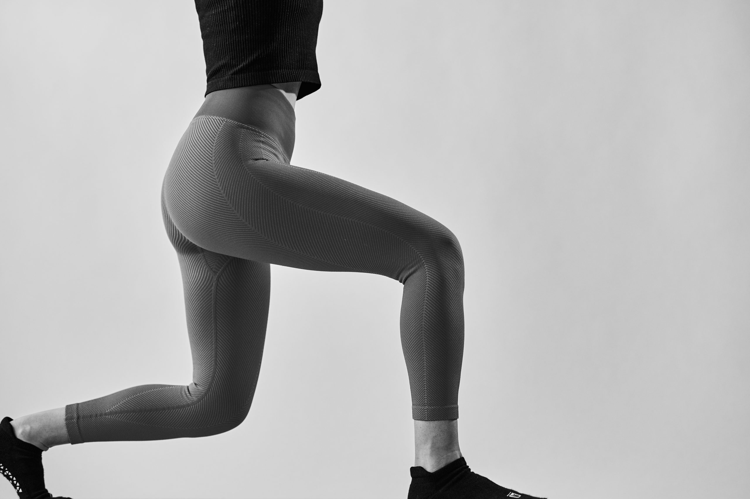 Black and white image of woman's back on a bar method studio