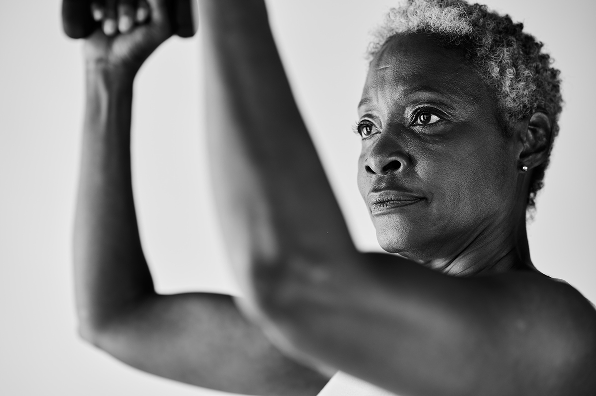 Black and white image of woman's back on a bar method studio