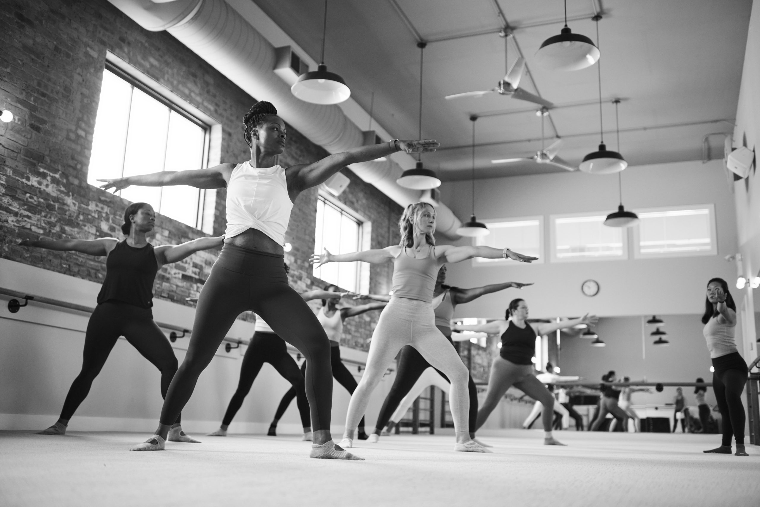 Black and white image of a group of people on a barre cardio class