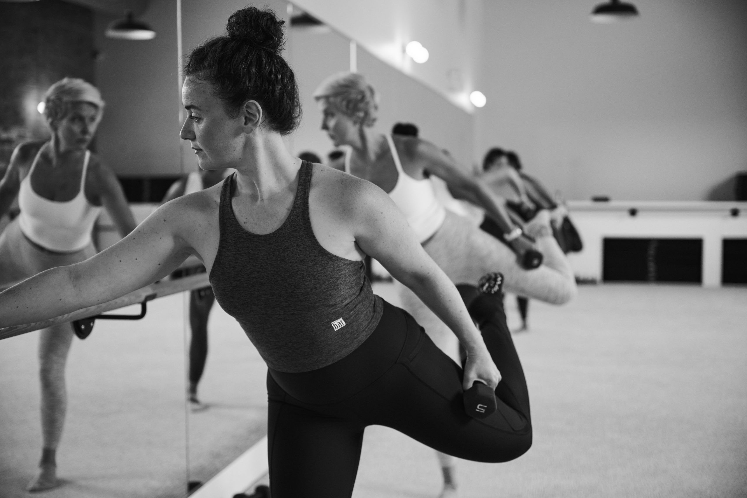 Black and white image of a group of people on a barre cardio class