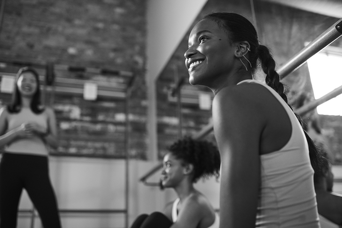 Several women are in a Bar Method studio hanging out and smiling.