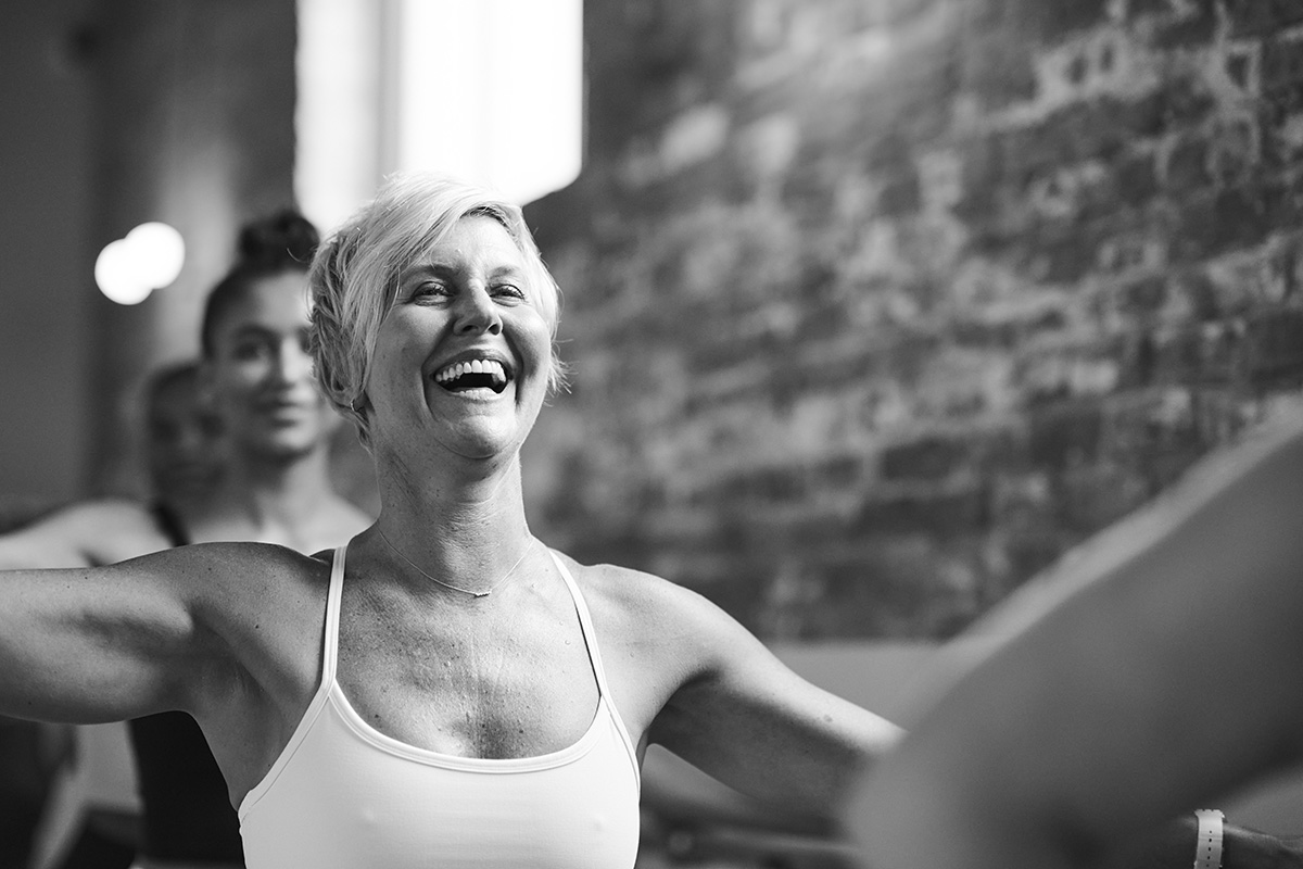Smiling woman in a Bar Method studio, emphasizing the benefits of exercise during perimenopause.