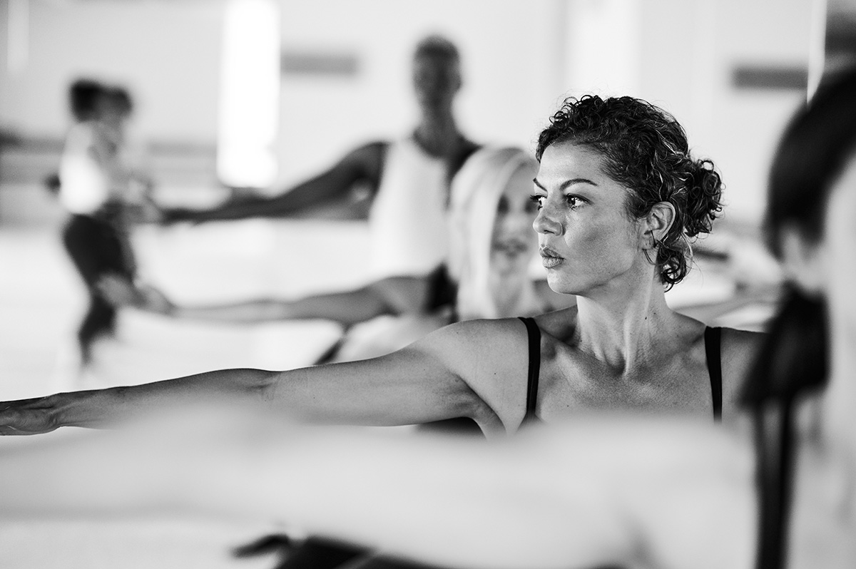 Group of women in a Bar Method studio, holding a pose at the barre.