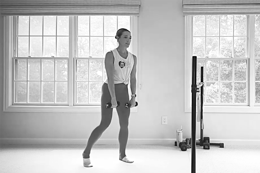 Woman in a barre studio demonstrating kickstand RDLs, one of the stability exercises featured in The Bar Method.