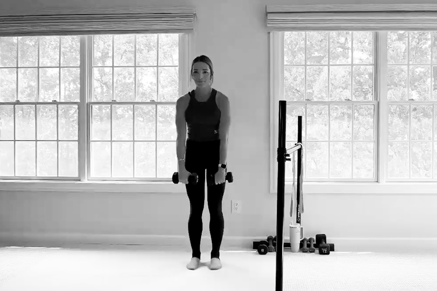 Woman in a barre studio demonstrating a weighted tilted lateral lunge, one of the stability exercises featured in The Bar Method.
