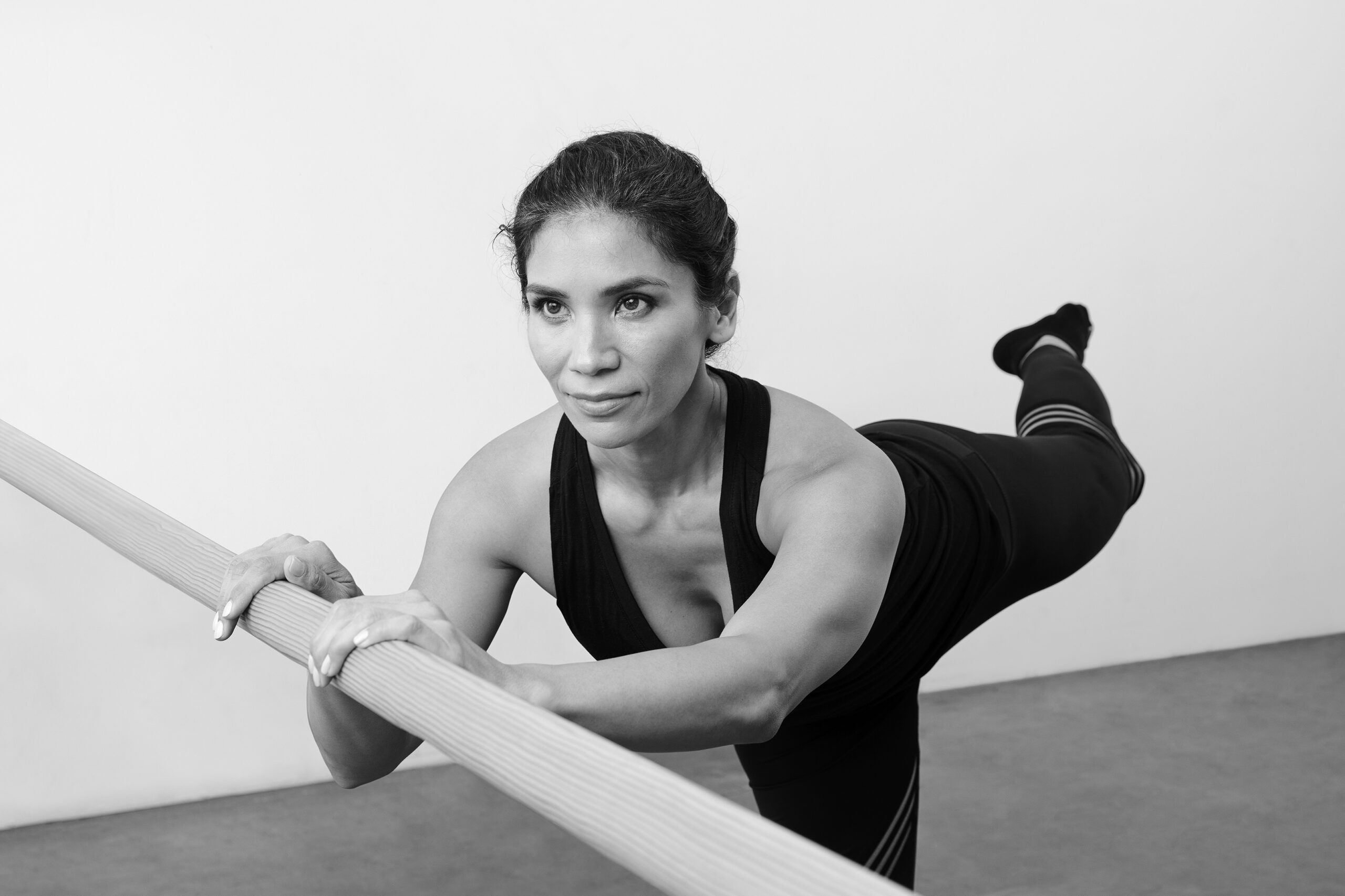 Bar Method instructor demonstrating arabesque, part of a barre back workout.