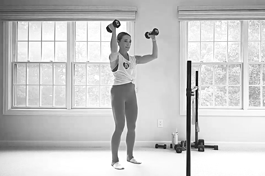 Bar Method instructor demonstrating bent-elbow lifts, part of a barre back workout.