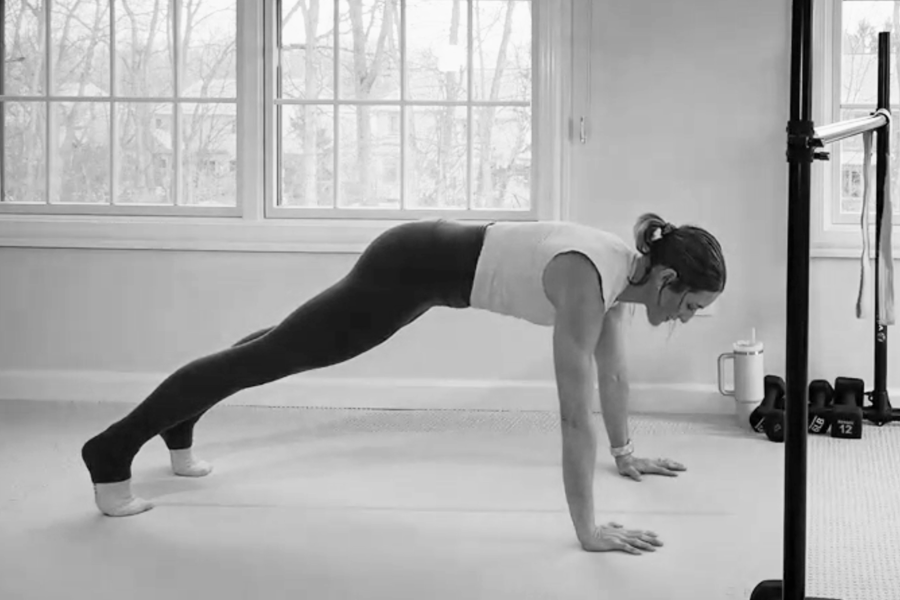 Bar Method instructor demonstrating push-ups, part of a barre back workout.