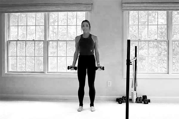 Bar Method instructor demonstrating snow angels, part of a barre back workout.